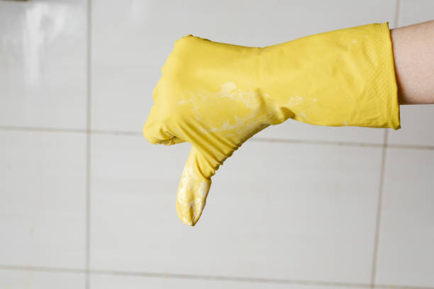 istock Hand in yellow rubber glow showing thumb down 1134910453