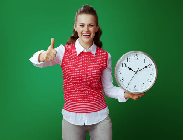 istock happy student woman with white round clock showing thumbs up 1134910567