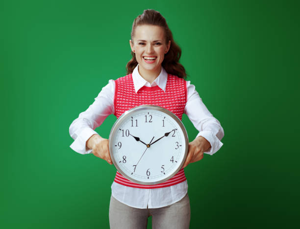 istock student showing white round clock isolated on green background 1134911191