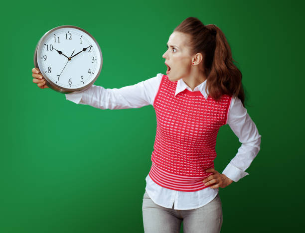 istock learner woman looking at white round clock isolated on green 1134911195