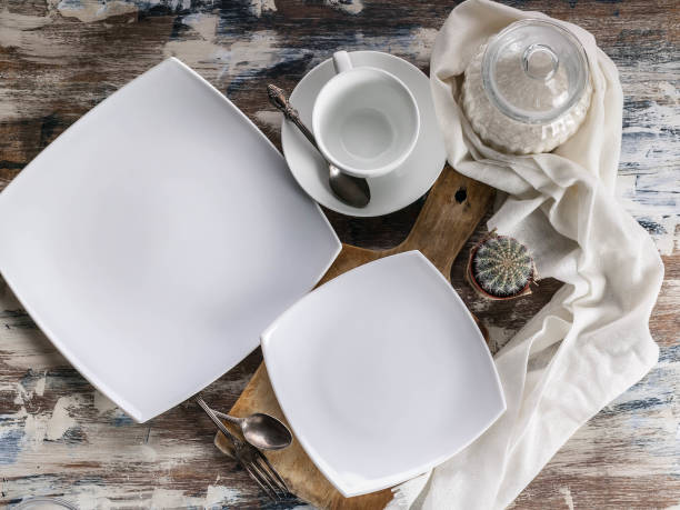 istock White Empty square plates and bowls. Set of white dishes on a wooden rustic table. Top view 1134911820