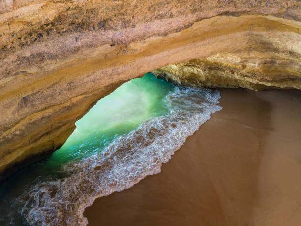 Famous natural cave at Benagil beach in Algarve Portugal.  landscape at one of the main holiday destinations in europe. Summer tourist attraction. Drone aerial view. Famous natural cave at Benagil beach in Algarve Portugal.  landscape at one of the main holiday destinations in europe. Summer tourist attraction. Drone aerial view. benagil photos stock pictures, royalty-free photos & images