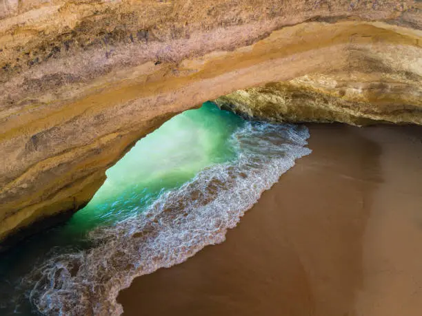 Famous natural cave at Benagil beach in Algarve Portugal.  landscape at one of the main holiday destinations in europe. Summer tourist attraction. Drone aerial view.