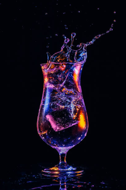 Water splash in a cocktail glass on black background. stock photo