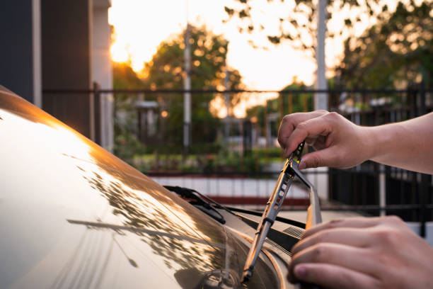 Technician is changing windscreen wipers on a car station Technician is changing windscreen wipers on a car station,man hand picking up windscreen wiper or Mechanic check old wiper blade on sedan car. windshield wiper stock pictures, royalty-free photos & images