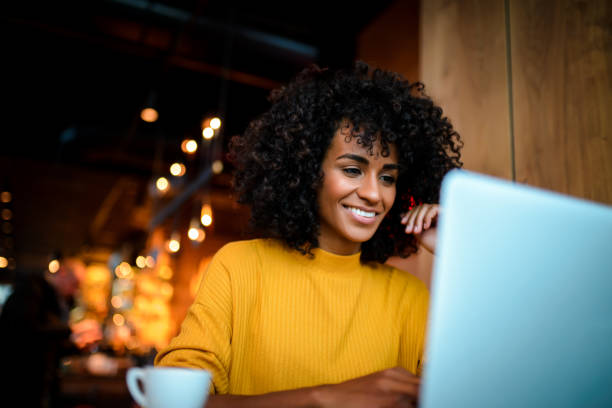 istock Smiling woman using laptop at the bar. 1134925803