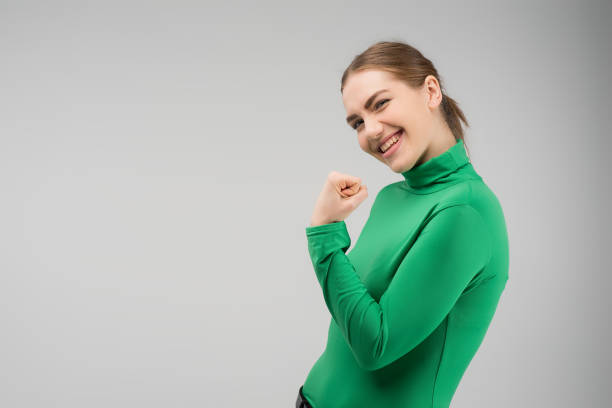 Happy young woman looking at the camera with cleanch fist up and smiling  .- Image