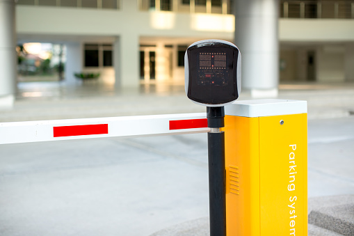 car park automatic entry system. Security system for building access - barrier gate stop with toll booth, traffic cones.