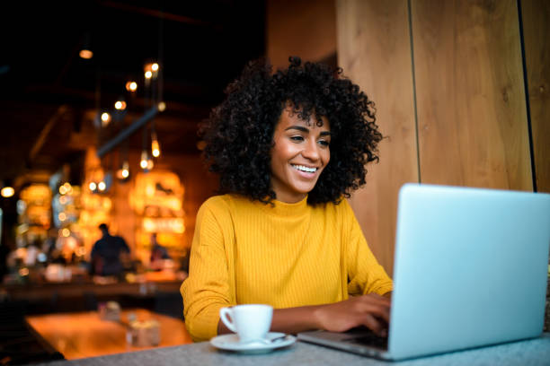 istock Smiling woman using laptop at the bar. 1134927057