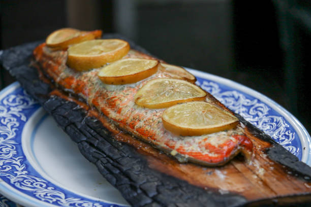 salmone alla griglia con limone e aneto cotti su una tavola di cedro - lemon fruit portion citrus fruit foto e immagini stock