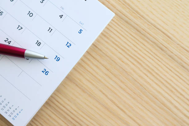 istock calendar page on wood table background with pen point at 19th date 1134930422