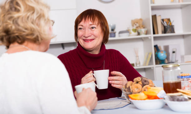istock cheerful mature females talking and drinking tea 1134931532