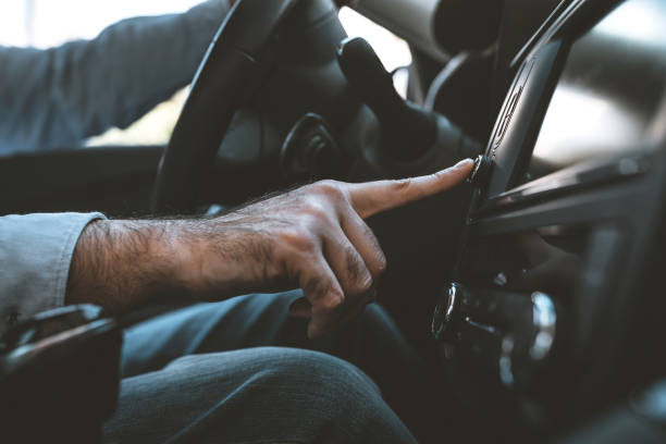 istock Man of style and status. Handsome young man in full suit smiling while driving a car 1134932688