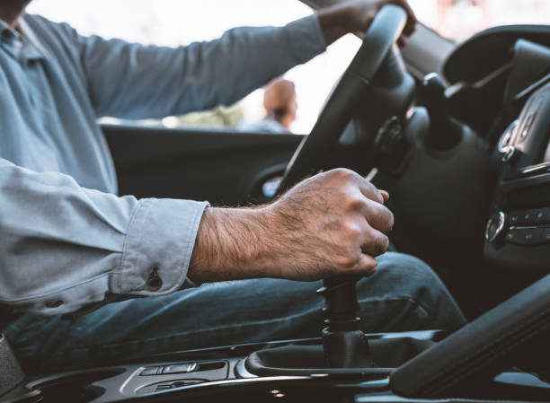 istock Man of style and status. Handsome young man in full suit smiling while driving a car 1134933105