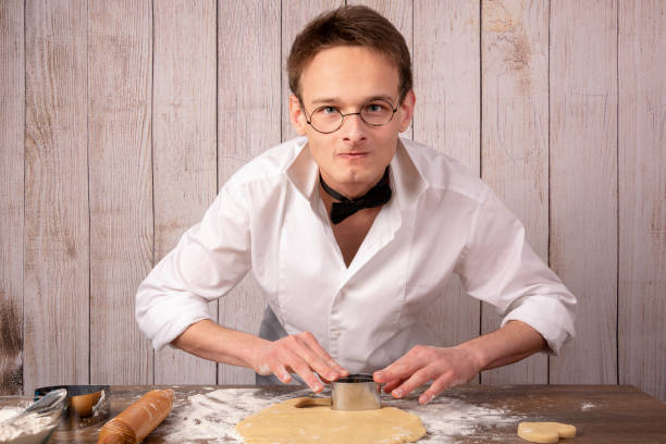 istock Pastry guy in a business suit preparing cookies 1134933147
