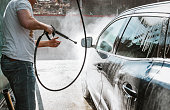Man washing his car with high-pressure washing