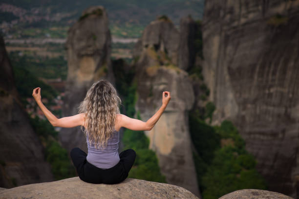 istock Woman meditating at Meteora,Greece 1134937386
