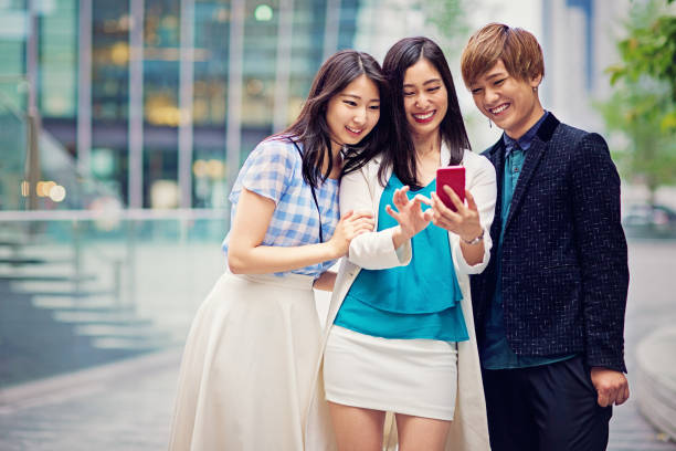 istock Young Japanese friends are looking in a mobile phone and texting 1134937449