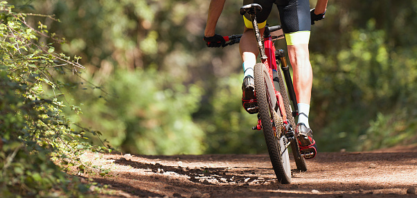 Mountain biker riding on bike singletrack trail, mountain bike race