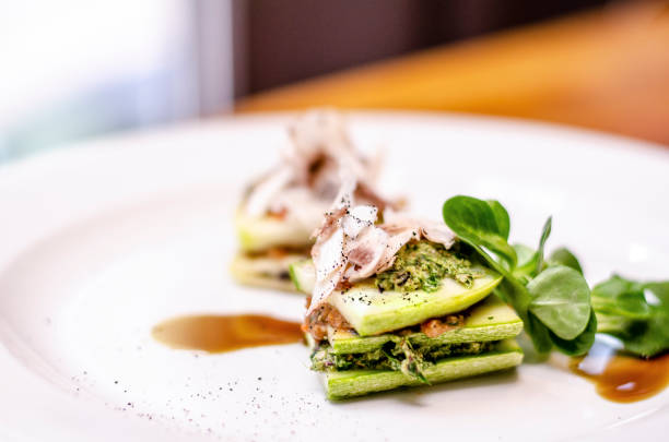 Vegan raw zucchini lasagna with pesto and tomato sauce served on a plate