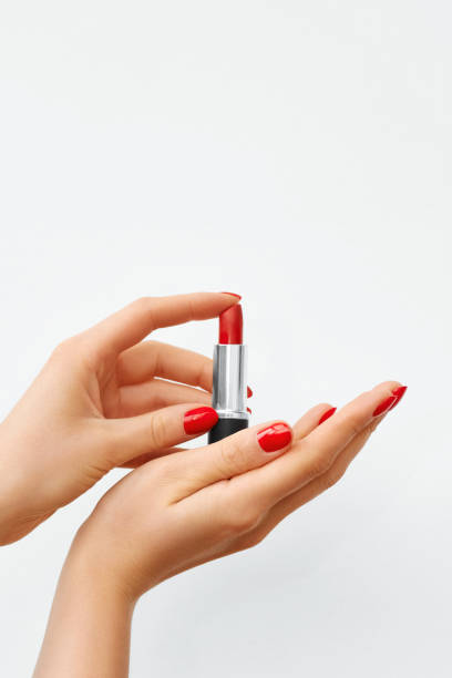 istock Woman's Hands with Red Nail Polish and Red Lipstick on a White Background 1134939672