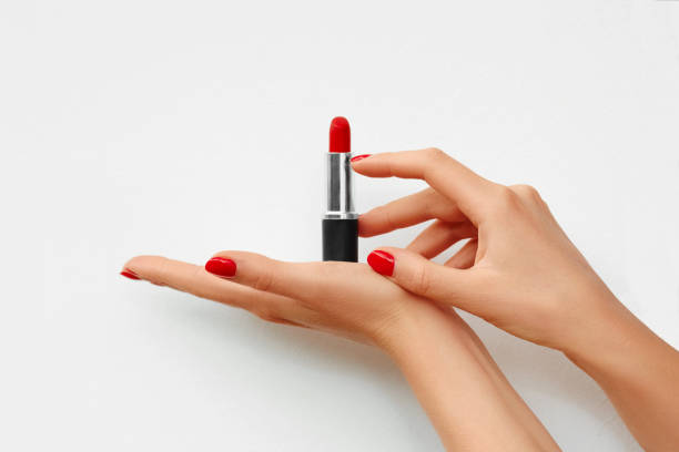 istock Open lipstick in a woman's hand isolated on white background. Red nails. Advertisement. Space for text on the background 1134939674