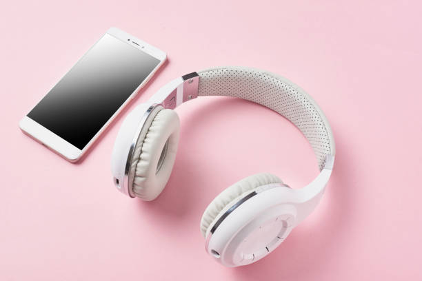 istock White wireless headphones and smartphone on a pastel pink background 1134940260