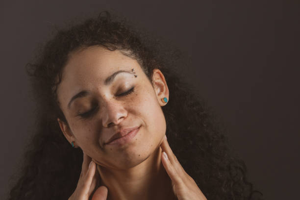Mixed Race Young Adult Woman Massaging Her Neck Mixed Race Young Adult Woman Massaging Her Neck relieved face stock pictures, royalty-free photos & images