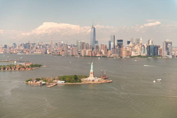 panorama aéreo de manhattan com a estátua da liberdade e do console de ellis em um dia ensolarado bonito - statue liberty statue of liberty ellis island - fotografias e filmes do acervo