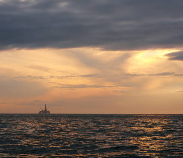 istock Dramatic cloudy sky over dark water ripple surface sea, yellow sunlight. 1134947943