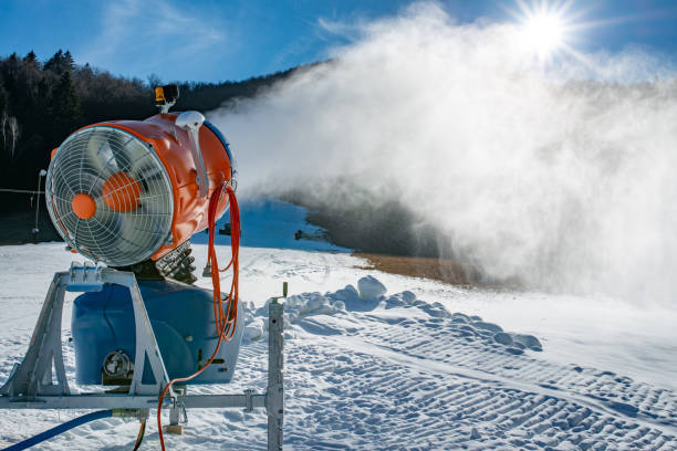istock Snow machine blowing artificial snow over a ski slope on a sunny day 1134948411