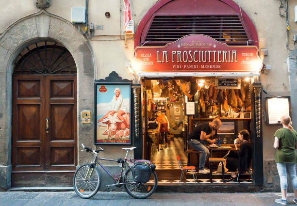 pareja joven tienen almuerzo en restaurante de carne en la calle histórica de la antigua ciudad de toscana - italian culture wall italy ancient fotografías e imágenes de stock