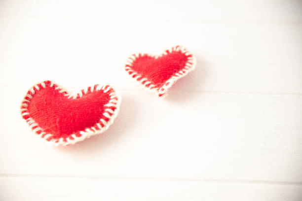 istock Red knitted soft fabric hearts on white background 1134949906