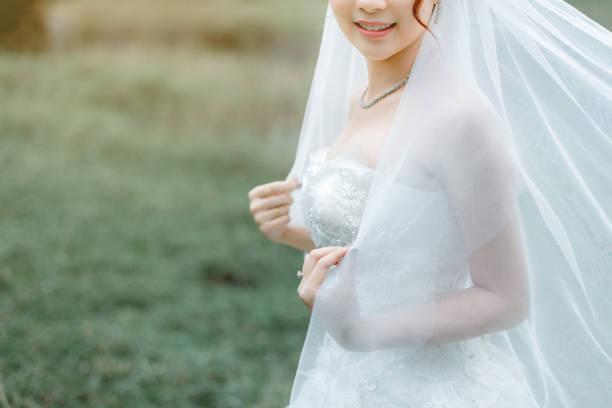 istock A beautiful bride wearing a wedding ring holds her veil. 1134950459