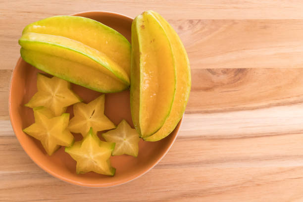 comer saludablemente. fruta fresca madura estrella (starfruit/carambola/averrhoa carambola). copiar espacio en el lado derecho - carambola o carambola averrhoa carambola en el árbol fotografías e imágenes de stock