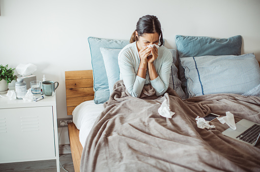 Woman with flu in bed, she use home medicine to handle sickness