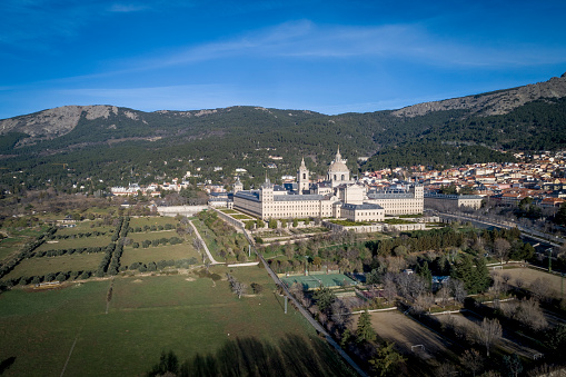 Aerial view of the Monastery of El Escorial at sunrise in spring with the Guadarrama mountains at the bottom