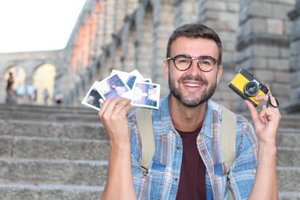 istock Retro photographer holding instant pics 1134956828