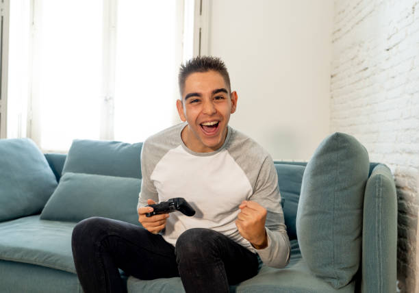 istock Portrait of young student man playing video games having fun winning the game using wireless remote joystick with freak intense happy face in Male game addiction to console play station and video. 1134957110