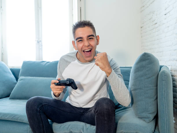 istock Portrait of young student man playing video games having fun winning the game using wireless remote joystick with freak intense happy face in Male game addiction to console play station and video. 1134957127