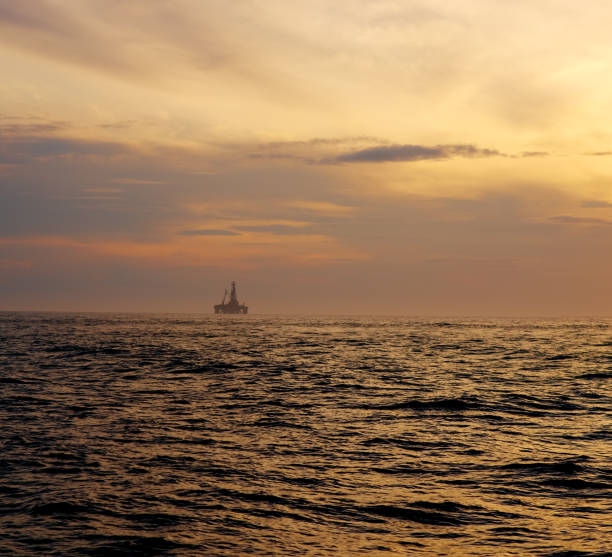 istock Dramatic cloudy sky over dark water ripple surface sea, yellow sunlight. 1134957358