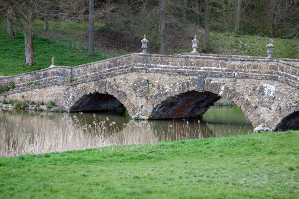 istock Old stone three arch bridge with tarmac road over a river 1134958595