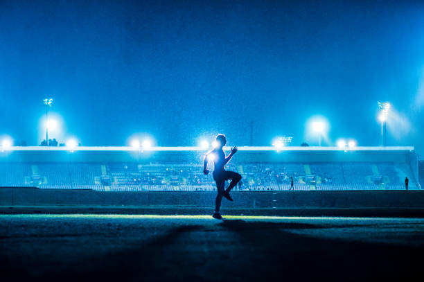 istock Running exercising warming up young athlete in front of stadium floodlights blue 1134958751