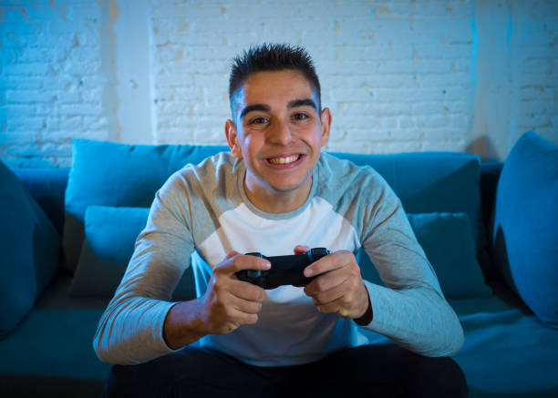 istock Portrait of young man having fun playing video games using wireless remote joystick with freak intense happy face celebrating winning. In Male game addiction to console play station and video. 1134959944