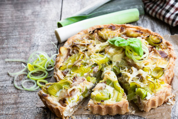 tarta de puerro con tocino y queso sobre mesa de madera - tart fotografías e imágenes de stock