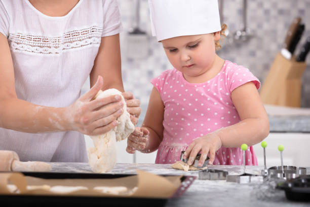 istock Cute Daughter Helping Her Mother To Make Cookies 1134962129