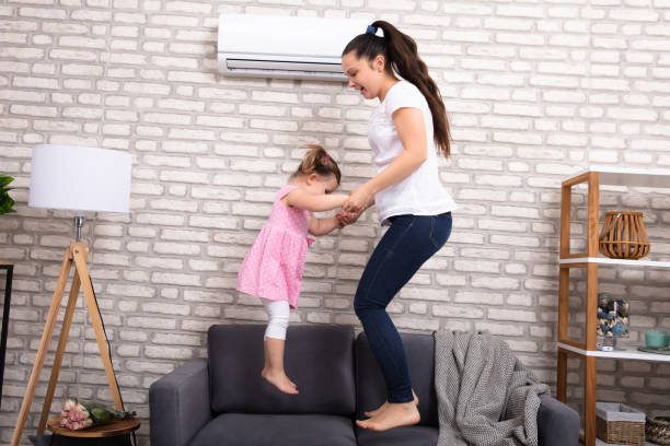 istock Smiling Mother And Daughter Jumping On Sofa 1134962161