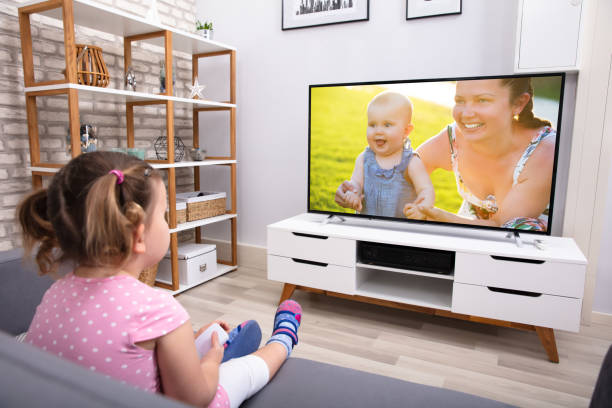 istock Girl Sitting On Sofa Watching Television 1134962174