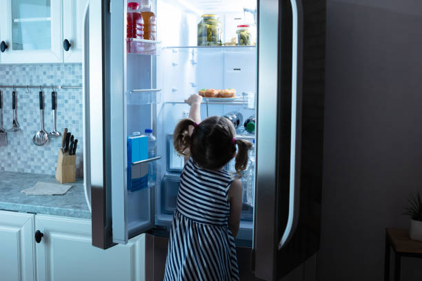 little girl try to take muffins from refrigerator - preservative imagens e fotografias de stock