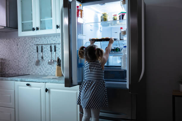 istock Little Girl Try To Take Muffins From Refrigerator 1134962185